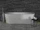 Freistehende Badewanne mit moderner Armatur von Ideal Standard, neben einem schwarzen Beistelltisch mit Pflegeprodukten, vor einer strukturierten dunklen Wand.